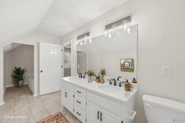 bathroom featuring vanity, toilet, a textured ceiling, and vaulted ceiling