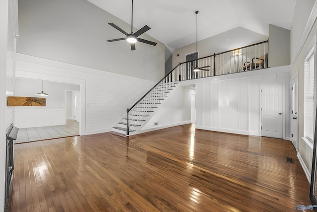 unfurnished living room featuring hardwood / wood-style floors, ceiling fan, and high vaulted ceiling