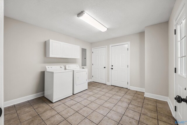 washroom featuring cabinets, a textured ceiling, light tile patterned floors, washing machine and clothes dryer, and electric panel