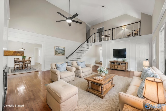 living room featuring ceiling fan, high vaulted ceiling, and hardwood / wood-style flooring