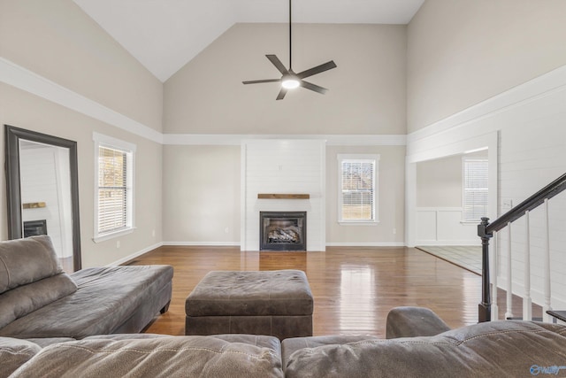 living room featuring wood-type flooring, high vaulted ceiling, a wealth of natural light, and ceiling fan