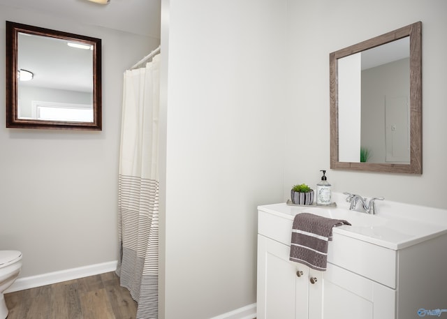 bathroom with toilet, hardwood / wood-style flooring, and vanity