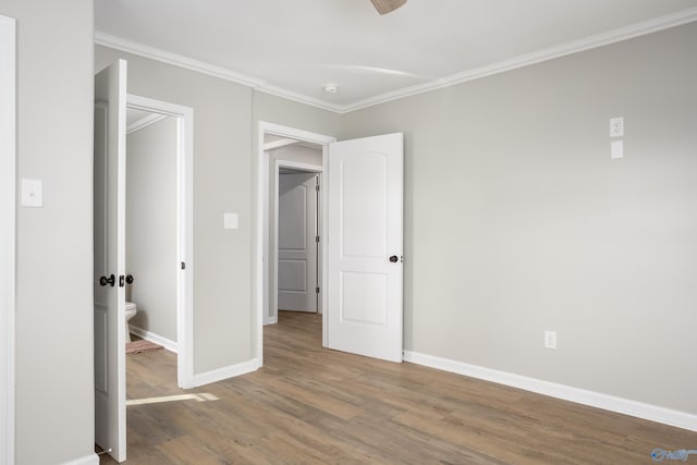 unfurnished bedroom featuring crown molding and hardwood / wood-style floors