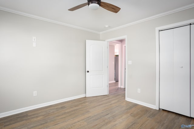 unfurnished bedroom with ceiling fan, ornamental molding, a closet, and hardwood / wood-style flooring