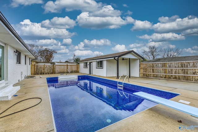 view of pool featuring a patio area, an outdoor structure, and a diving board