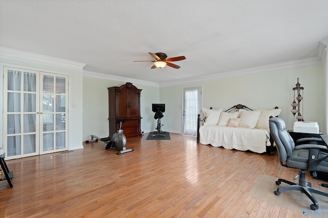 bedroom with a textured ceiling, french doors, light wood-type flooring, visible vents, and ornamental molding