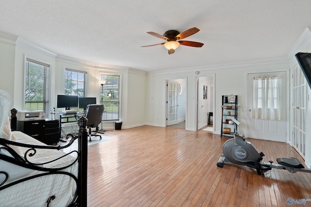 bedroom with wood-type flooring, a textured ceiling, and crown molding
