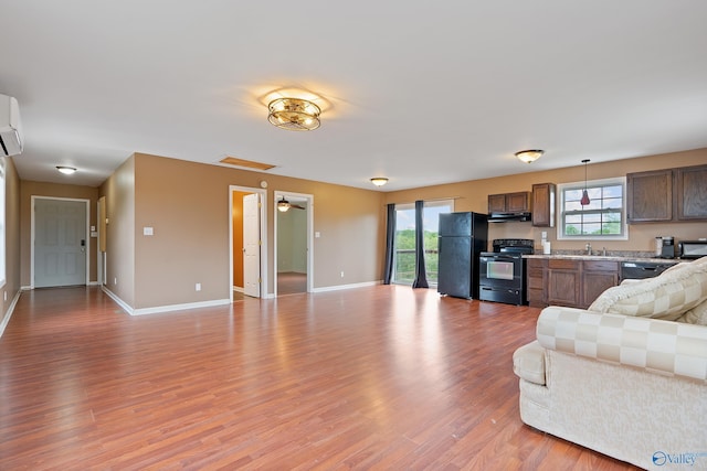living room featuring baseboards, visible vents, light wood-type flooring, and a wealth of natural light