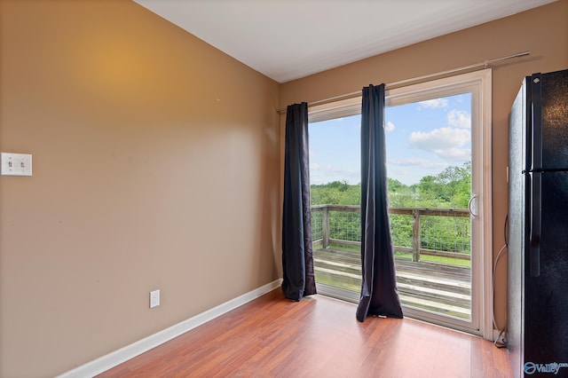 empty room featuring baseboards and light wood finished floors