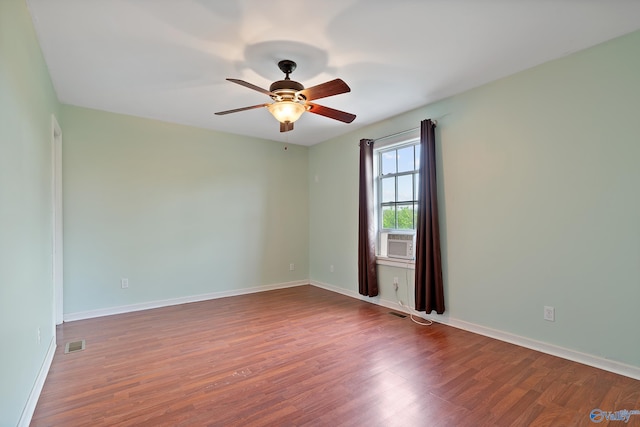 empty room featuring visible vents, baseboards, ceiling fan, and wood finished floors