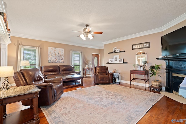 living area featuring dark wood-style flooring, ceiling fan, plenty of natural light, and ornamental molding