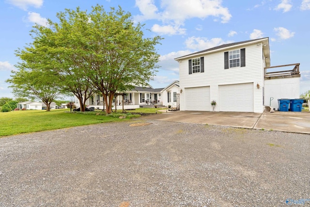 traditional-style home with an attached garage, a front lawn, driveway, and a residential view