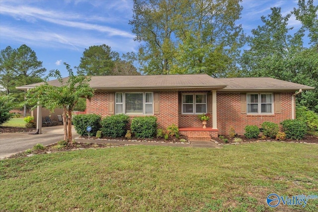 ranch-style home featuring driveway, brick siding, and a front lawn