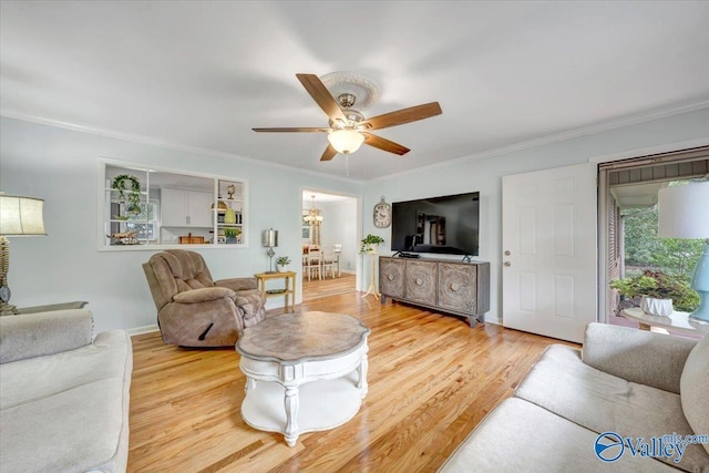 living area with baseboards, light wood-style floors, crown molding, and ceiling fan with notable chandelier