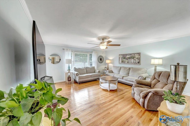 living area with light wood finished floors, baseboards, ornamental molding, a textured ceiling, and a ceiling fan