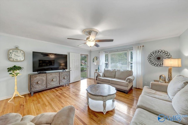 living area with ceiling fan, crown molding, baseboards, and wood finished floors