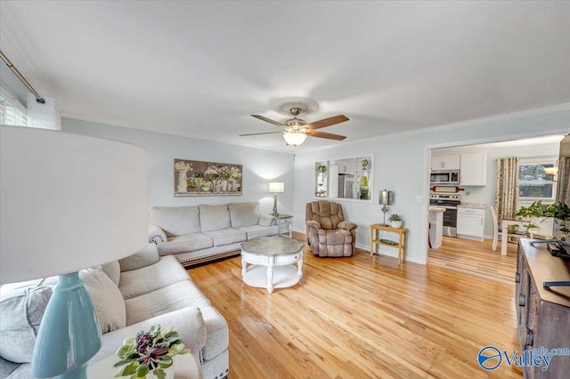 living area featuring crown molding, baseboards, light wood-type flooring, and ceiling fan