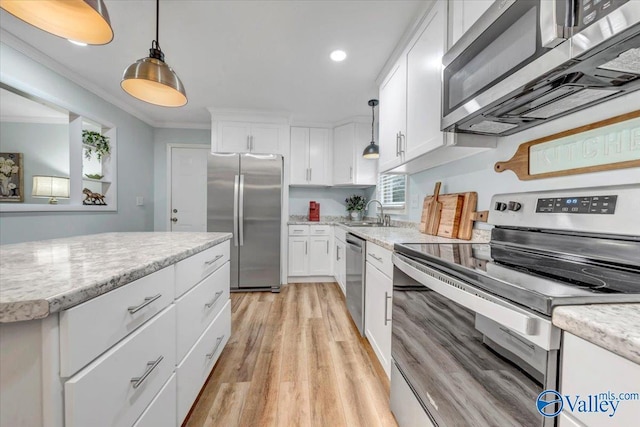 kitchen with stainless steel appliances, white cabinets, and crown molding