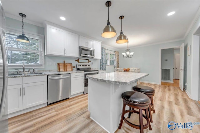 kitchen with visible vents, appliances with stainless steel finishes, crown molding, and a sink