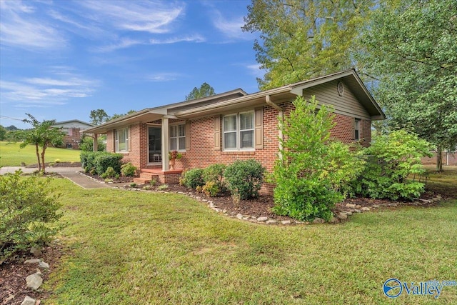 view of front of property featuring brick siding and a front lawn