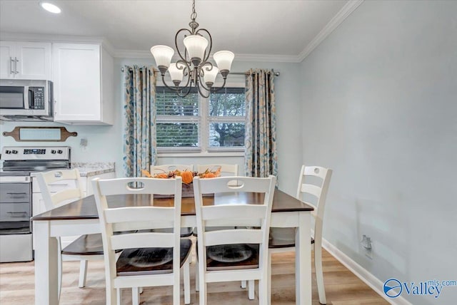 dining area with light wood-type flooring, baseboards, ornamental molding, and a chandelier