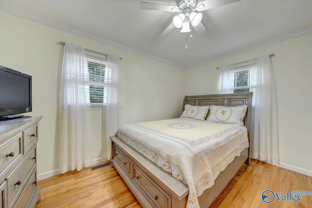 bedroom featuring visible vents, light wood-style flooring, baseboards, and ornamental molding