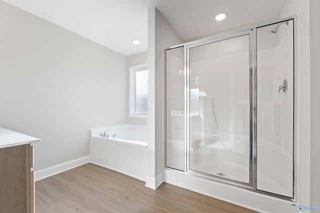 2159 Dawson Ln NE, Cullman, AL 35058 - full bathroom featuring vanity, baseboards, a shower stall, wood finished floors, and a bath