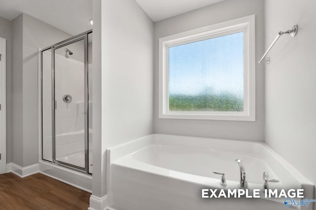 full bath with a garden tub, a shower stall, baseboards, and wood finished floors