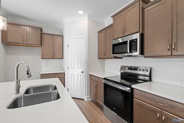 2159 Dawson Ln NE, Cullman, AL 35058 - kitchen with appliances with stainless steel finishes, wood finished floors, a sink, light countertops, and ornamental molding