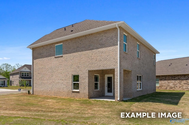 back of house with a patio area, brick siding, and a yard