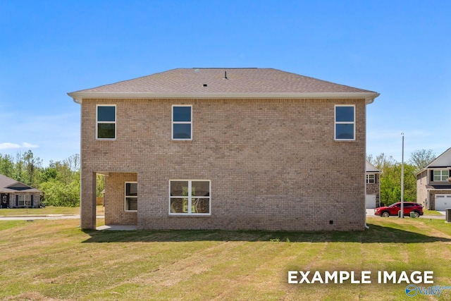 back of property with brick siding, roof with shingles, and a yard