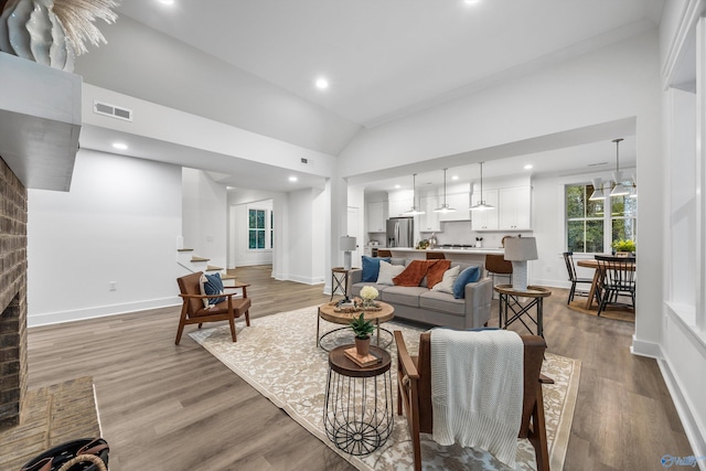 living room with light hardwood / wood-style flooring and vaulted ceiling