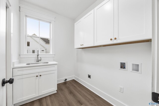 washroom with baseboards, hookup for a washing machine, dark wood finished floors, a sink, and cabinet space