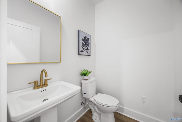 bathroom featuring toilet, wood-type flooring, and sink