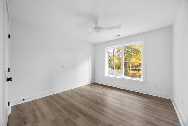 empty room featuring baseboards, ceiling fan, visible vents, and wood finished floors