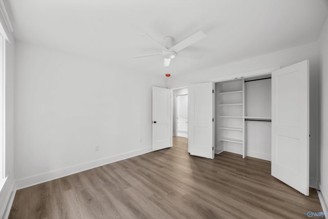 unfurnished bedroom featuring baseboards, a ceiling fan, a closet, and wood finished floors
