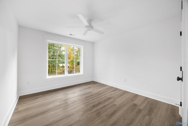 unfurnished room with visible vents, a ceiling fan, baseboards, and wood finished floors