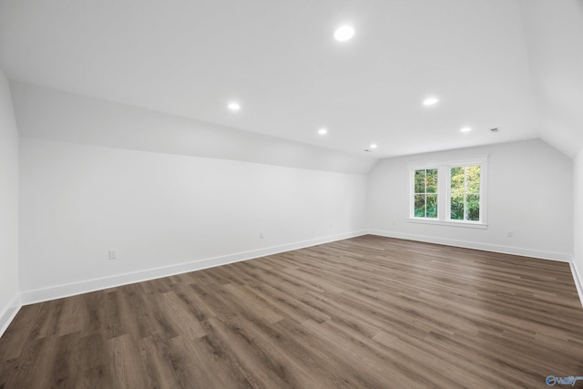 unfurnished room featuring dark hardwood / wood-style floors and vaulted ceiling