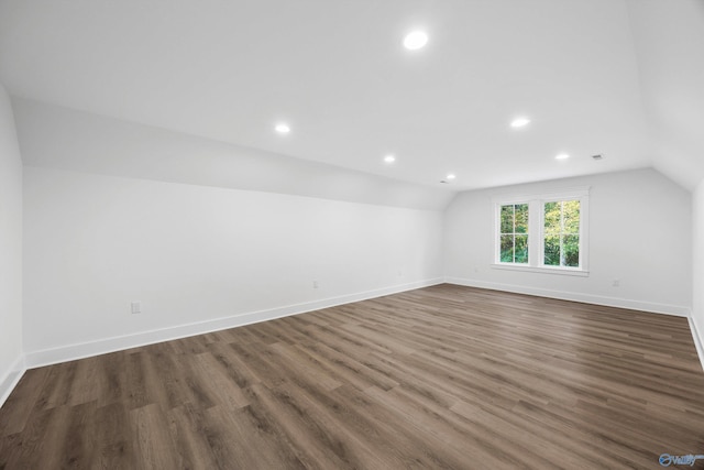 additional living space with recessed lighting, baseboards, vaulted ceiling, and dark wood-type flooring