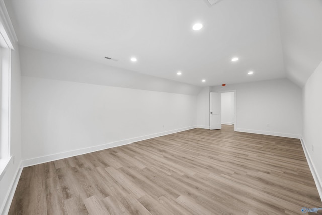 unfurnished room featuring light hardwood / wood-style floors and vaulted ceiling