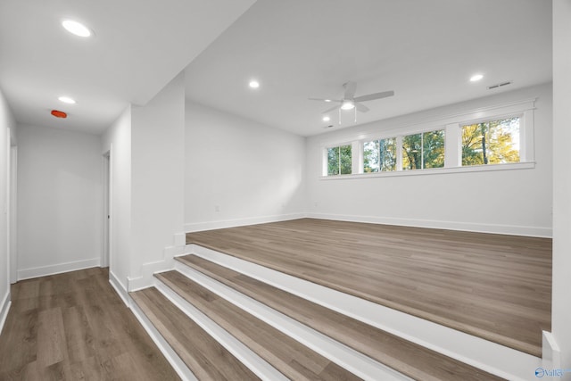 unfurnished room featuring ceiling fan, dark wood-type flooring, and a wealth of natural light