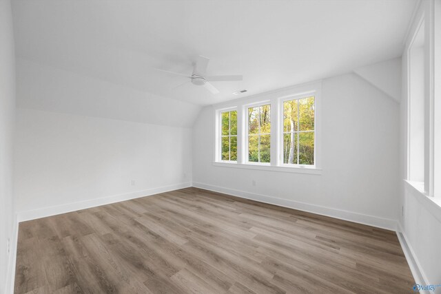 additional living space featuring baseboards, ceiling fan, wood finished floors, and vaulted ceiling