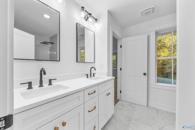 bathroom featuring visible vents, a sink, tile patterned flooring, and double vanity