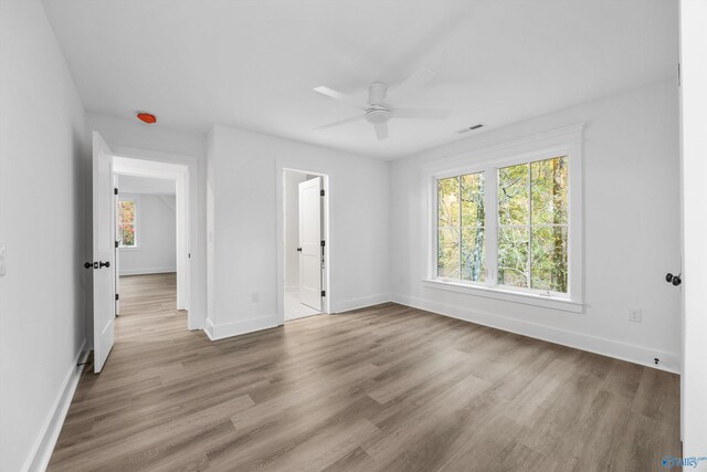 unfurnished bedroom with baseboards, wood finished floors, and visible vents