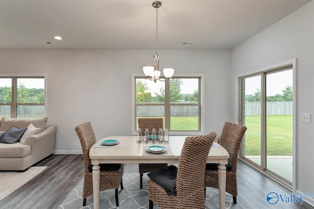 dining area with a healthy amount of sunlight, a notable chandelier, and wood-type flooring