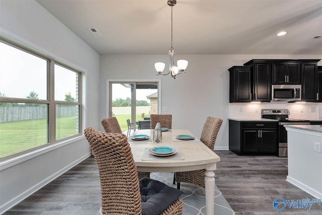 dining area with dark hardwood / wood-style floors and a chandelier