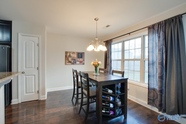 dining space featuring dark wood-type flooring, an inviting chandelier, and a wealth of natural light