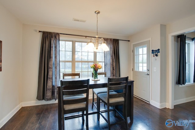 dining space featuring dark hardwood / wood-style floors and a chandelier