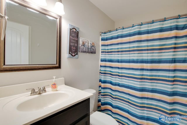 bathroom with vanity, lofted ceiling, a shower with shower curtain, and toilet