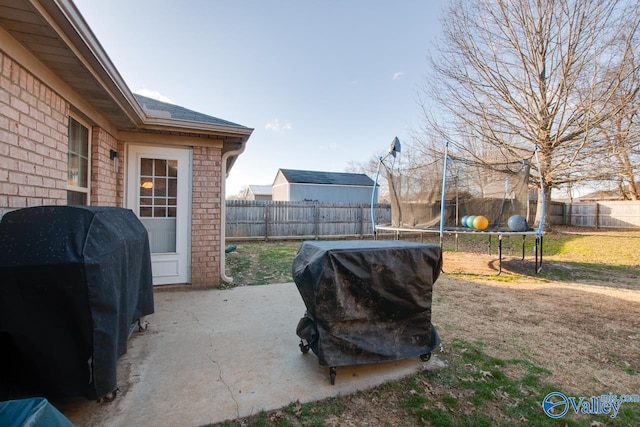 view of yard featuring a trampoline and a patio